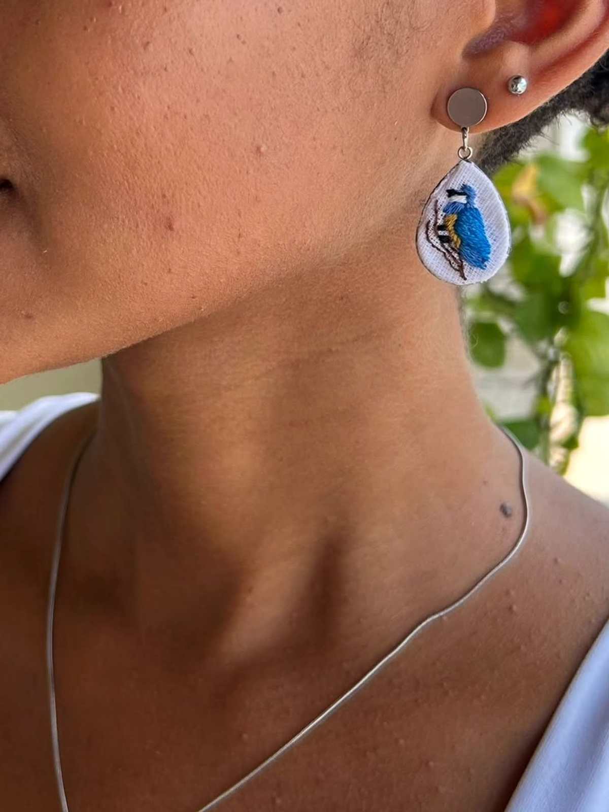 Detalhe do pingente Asas do Horizonte em aço prata