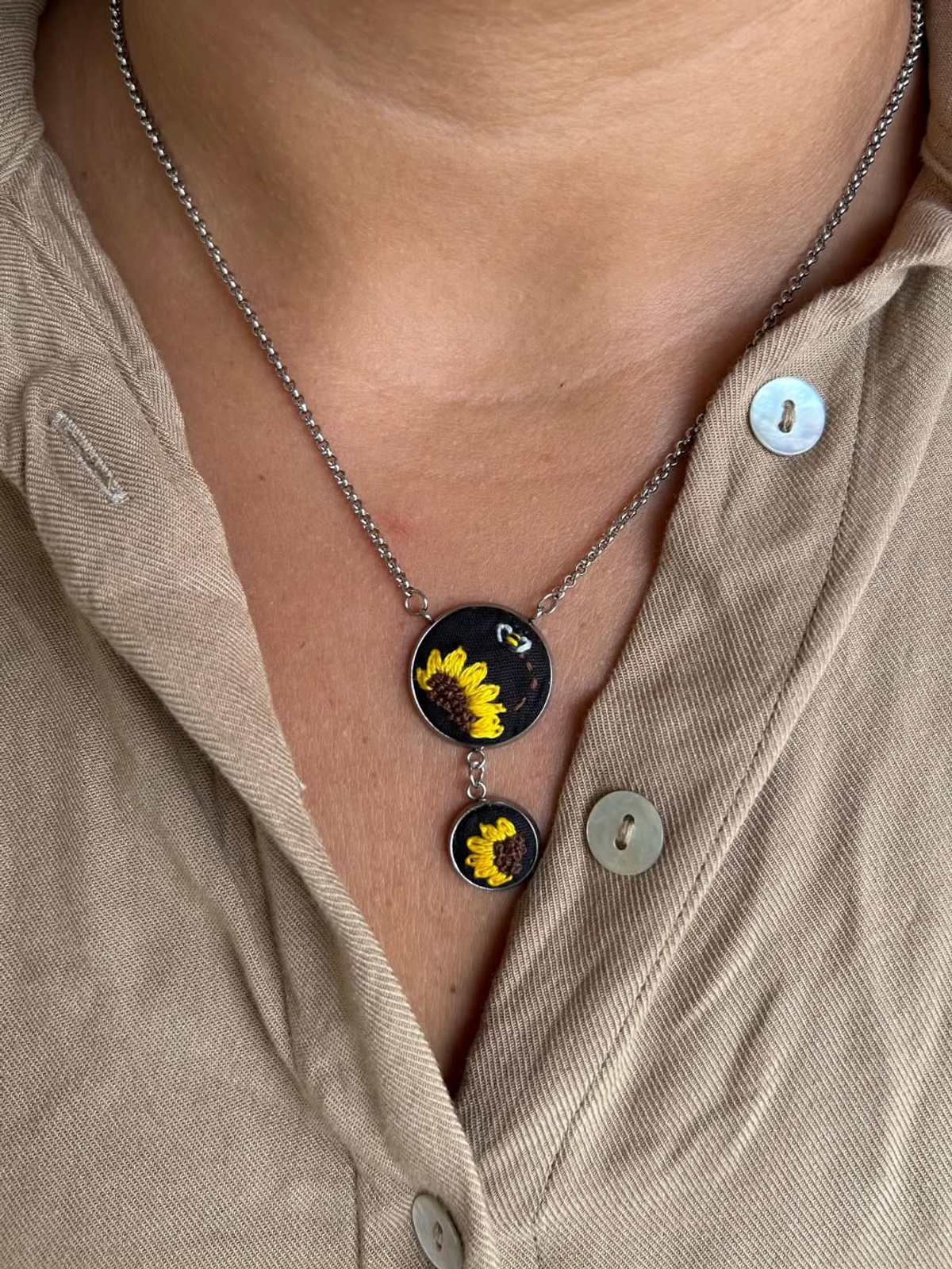 Colar Sol da Terra com pingente bordado no pescoço da modelo
