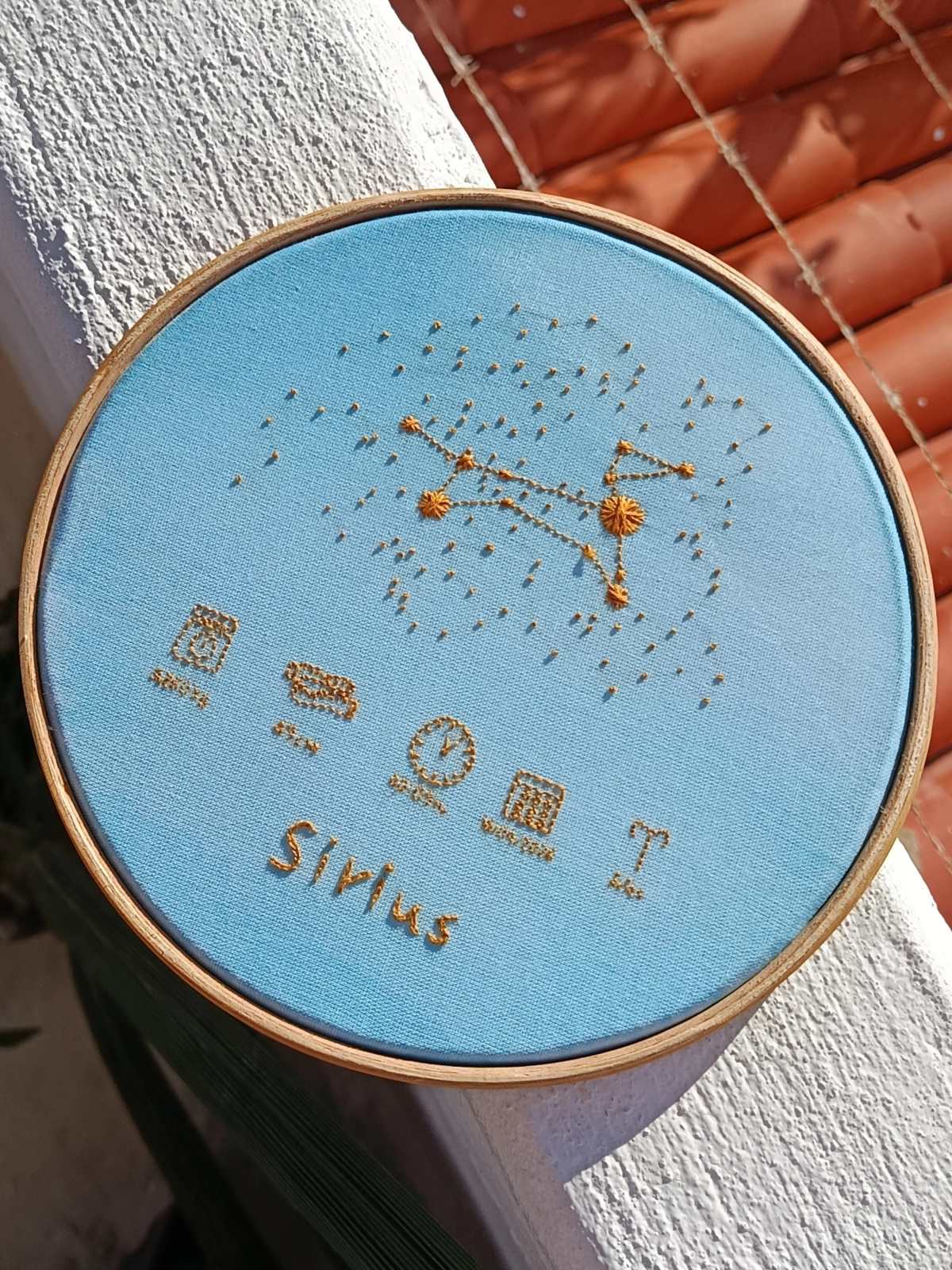 Porta maternidade em tecido azul com constelação, hora e data do nascimento bordados em dourado